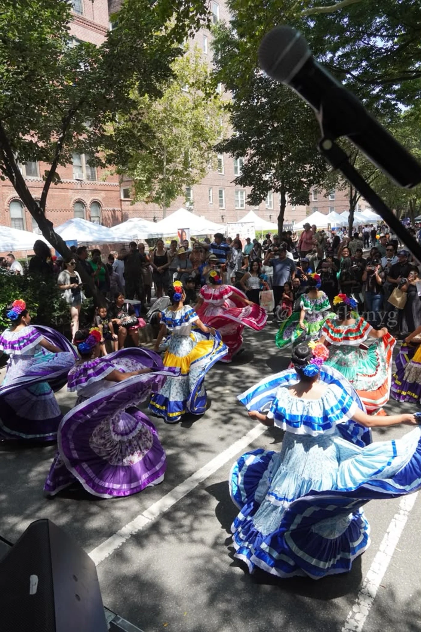 Folkloric dancers in colorful dresses performing at Jackson Heights Day